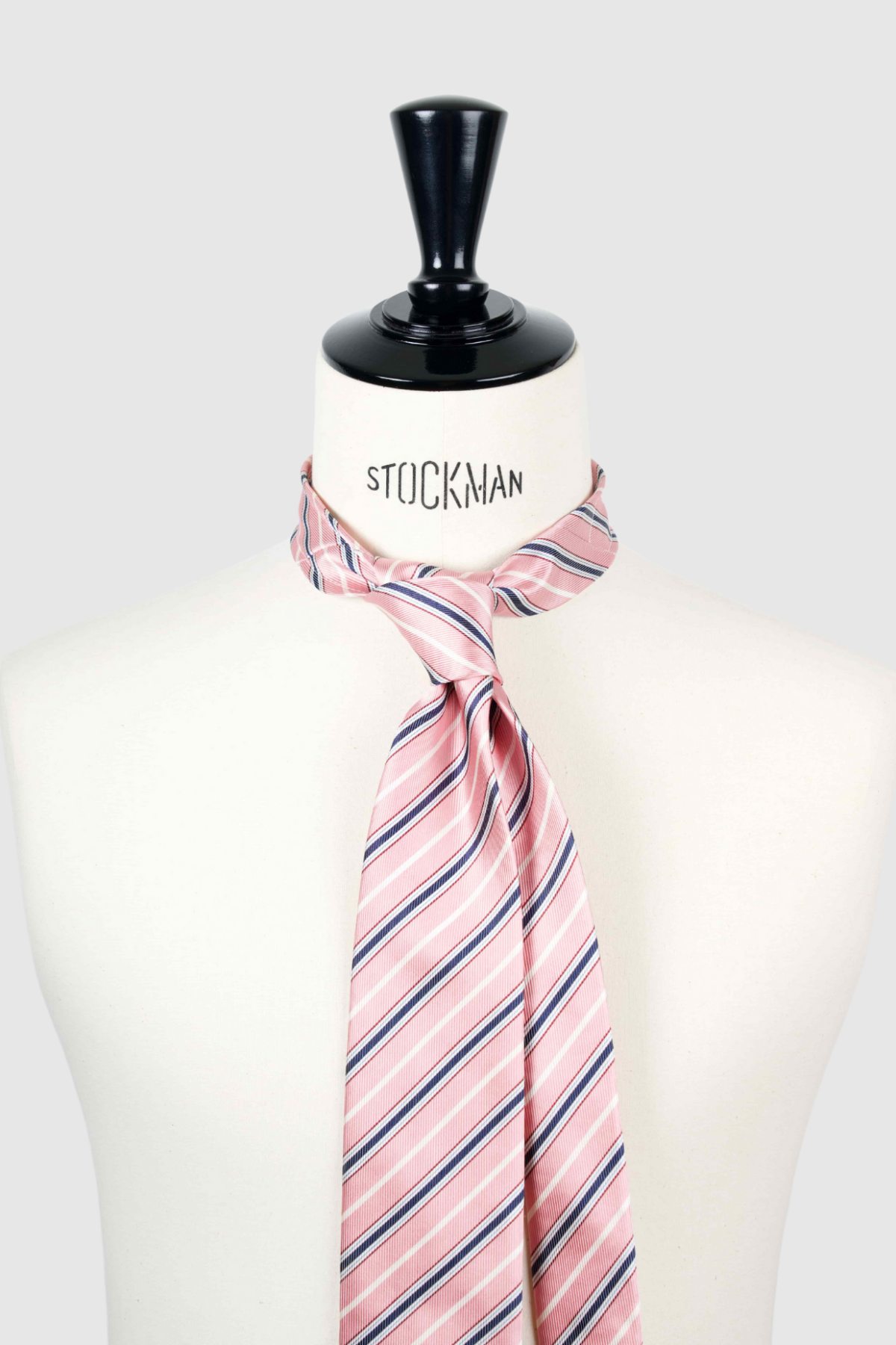 Cravate sartoriale à 3 plis, en soie tissée Jacquard, rose à rayures et aperçu du noeud simple sur buste Stockman.