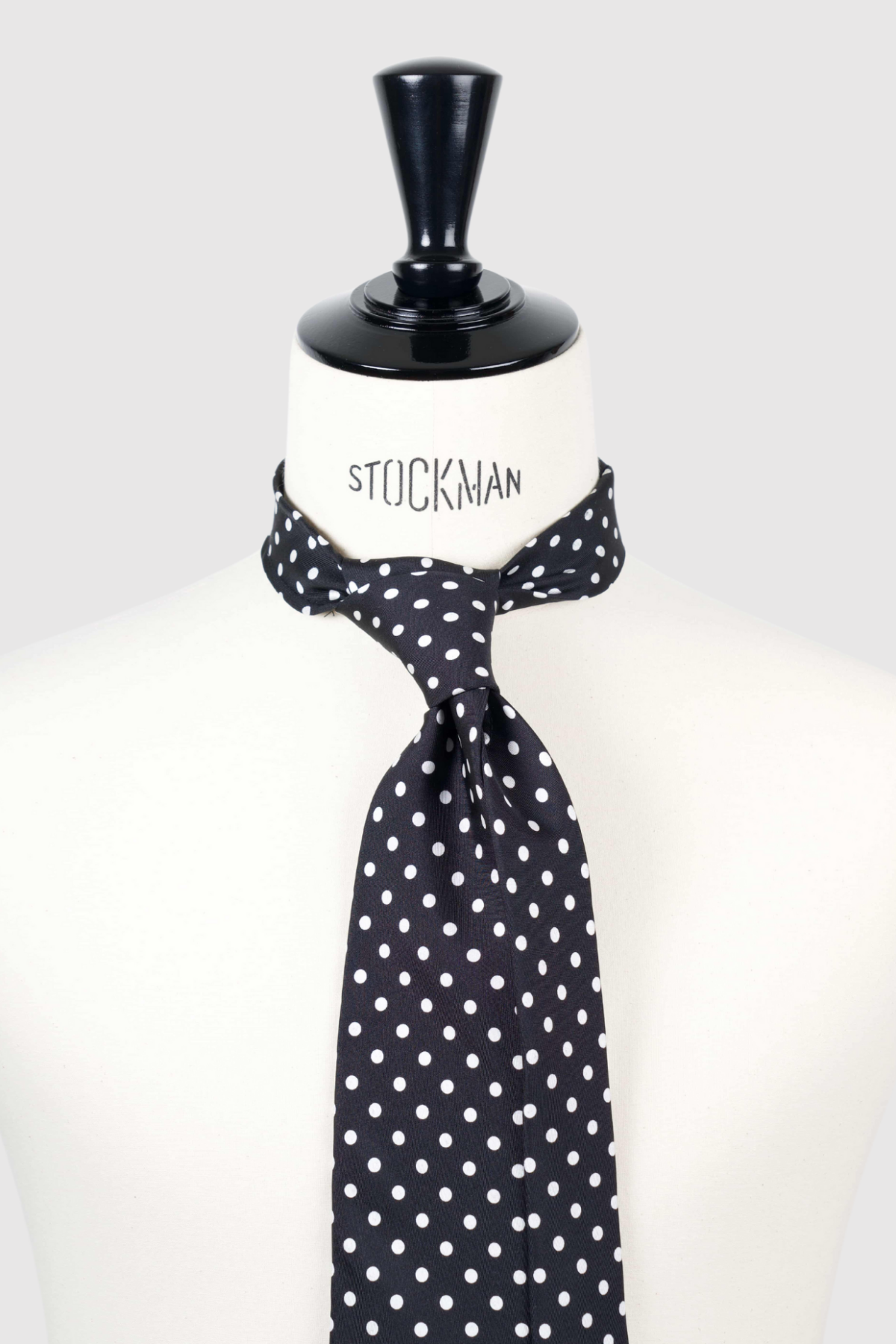 Cravate sartoriale à 3 plis, en soie imprimée, bleu marine, motif pois blancs et aperçu du noeud simple sur buste Stockman.