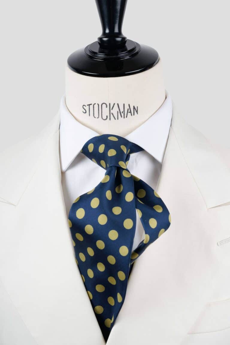 Cravate bleu marine à pois jaune, soie imprimée 3 plis artisanale, nouée sur un buste, chemise blanche, Dare in Paris