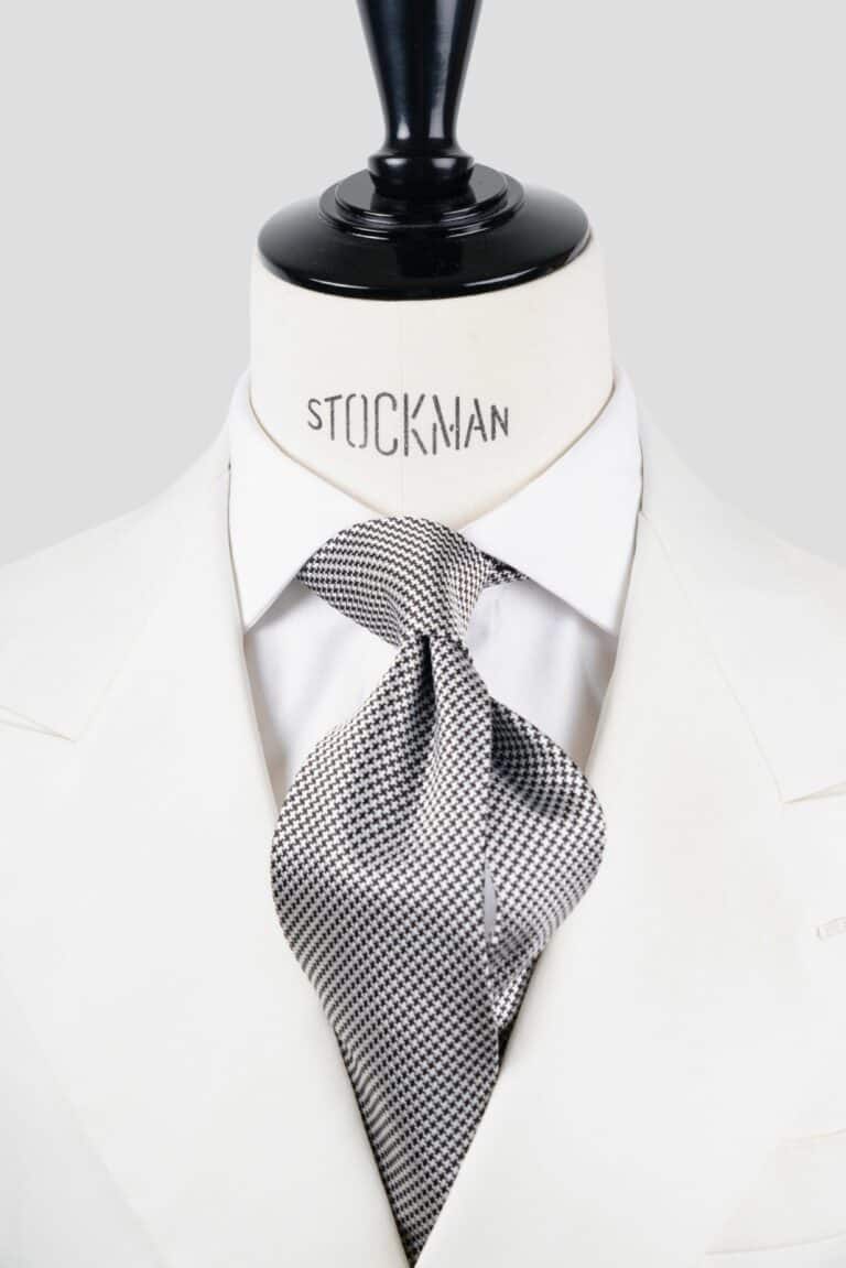 Cravate argent et noir, motif pied de poule, soie tissée 3 plis artisanale, nouée sur un buste, chemise blanche, Dare in Paris