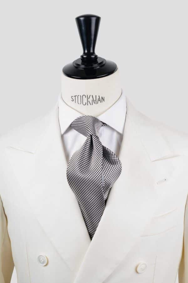 Cravate argent et noir, motif pied de poule, soie tissée 3 plis artisanale, nouée sur un buste, chemise blanche, Dare in Paris