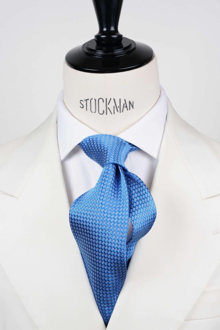 Cravate bleu ciel à motif blanc, soie tissée 3 plis artisanale, nouée sur un buste, chemise blanche, Dare in Paris