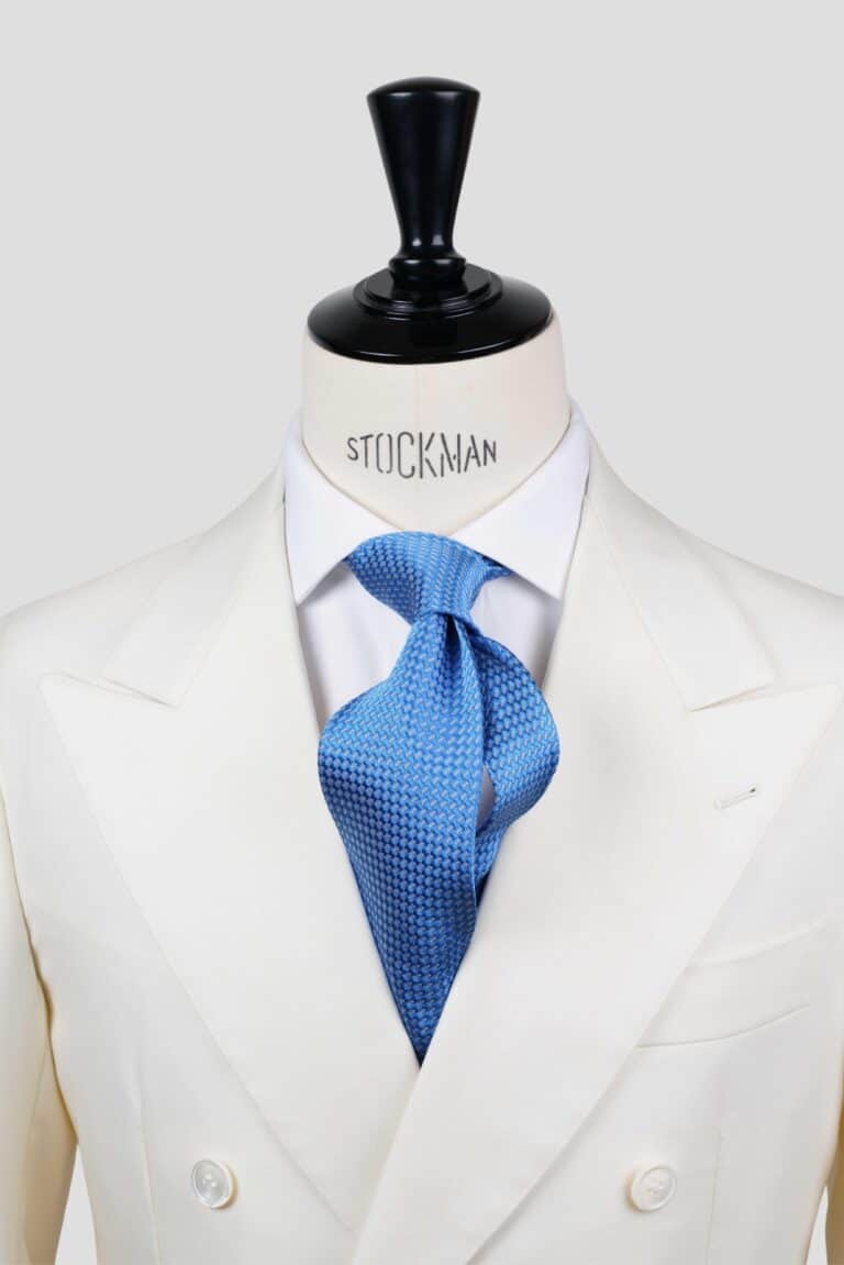 Cravate bleu ciel à motif blanc, soie tissée 3 plis artisanale, nouée sur un buste, chemise blanche, Dare in Paris