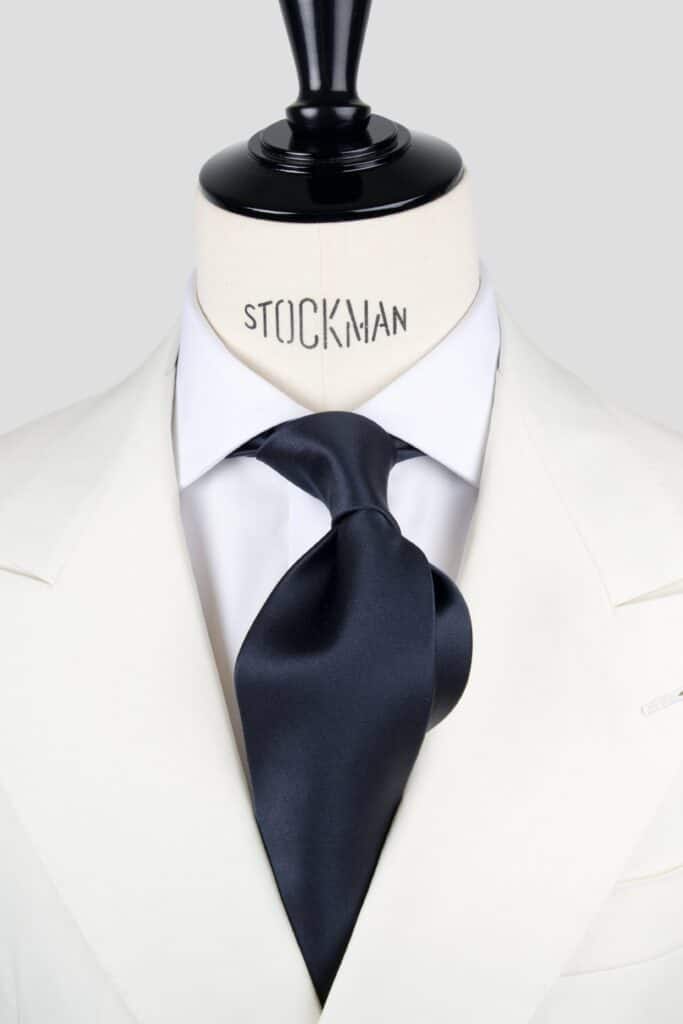 Cravate bleu marine unie - Soie satin 3 plis, nouée sur une chemise blanche, Dare in Paris