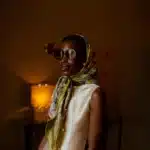 Carré de soie noué en foulard sur la tête, porté avec une robe crème, Dare in Paris