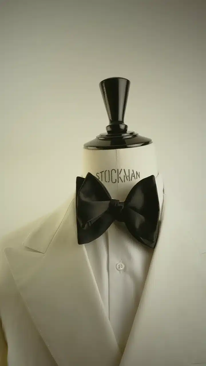 Nœud papillon noir noué sur une chemise blanche, buste de tailleur Stockman