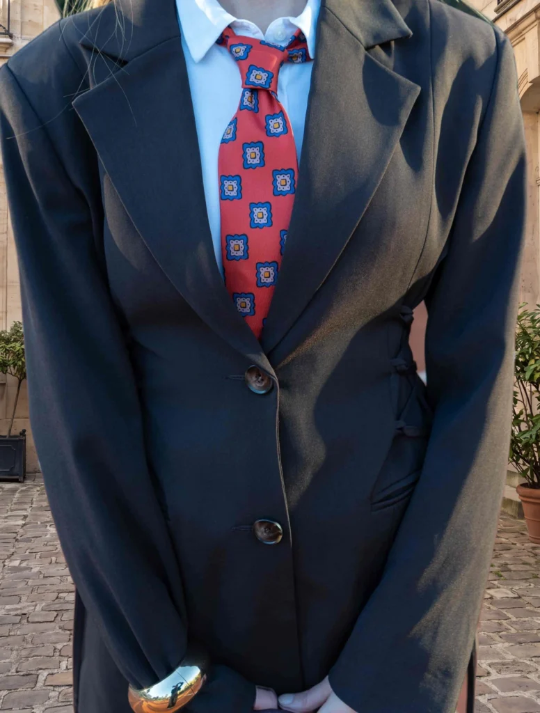 Cravate 7 plis rouge en soie, portée avec une chemise et une veste, vue rapprochée.