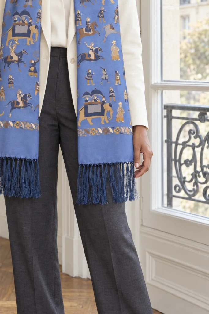 Foulard en soie bleu ciel, motif personnages, détail recadré du motif et du tissu de la vue portée.