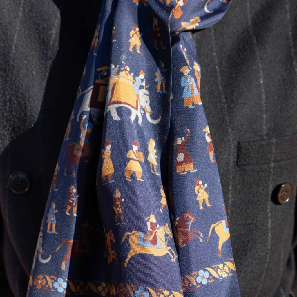 Foulard en soie bleu marine, motif personnages, détail recadré du motif et du tissu de la vue portée.