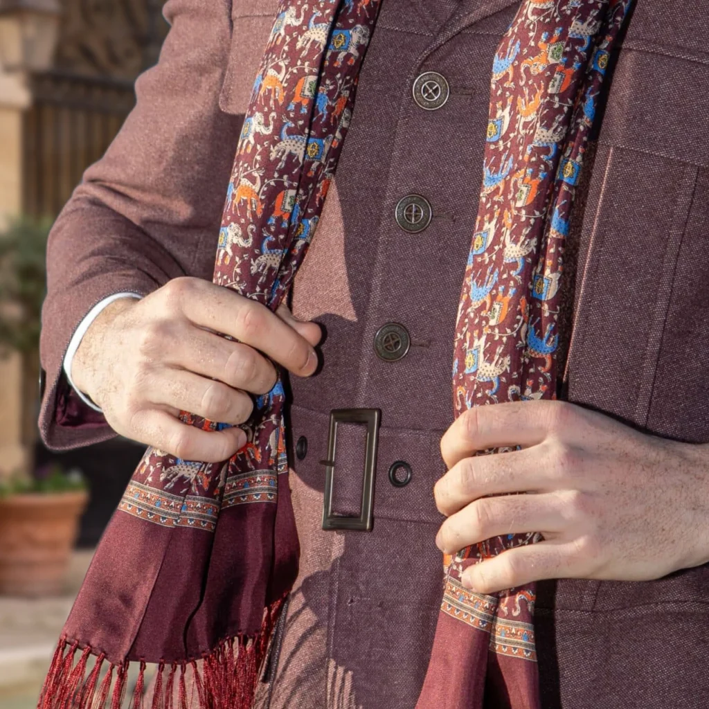 Foulard en soie bordeaux, motif éléphants, détail recadré du motif et du tissu de la vue portée.