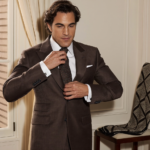 Homme en costume marron ajustant une cravate en soie texturée, inspiration Pitti Uomo 2027