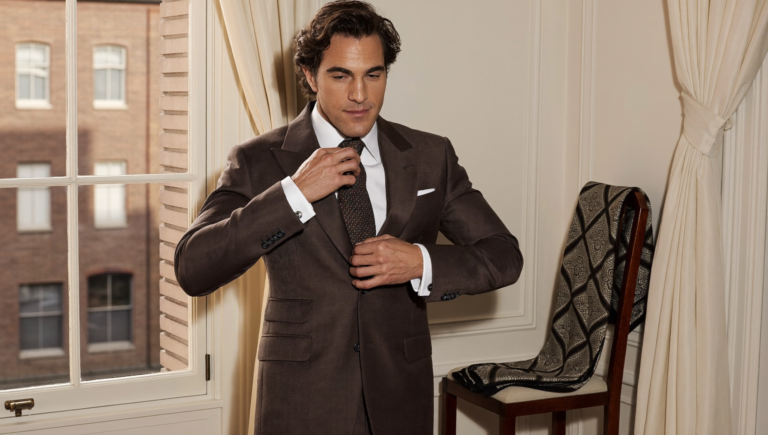 Homme en costume marron ajustant une cravate en soie texturée, inspiration Pitti Uomo 2027