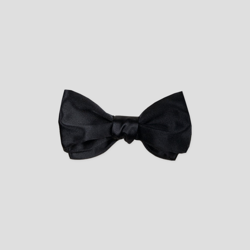 Nœud papillon noir satin de soie, L’Intemporel, présenté de face sur fond gris clair.